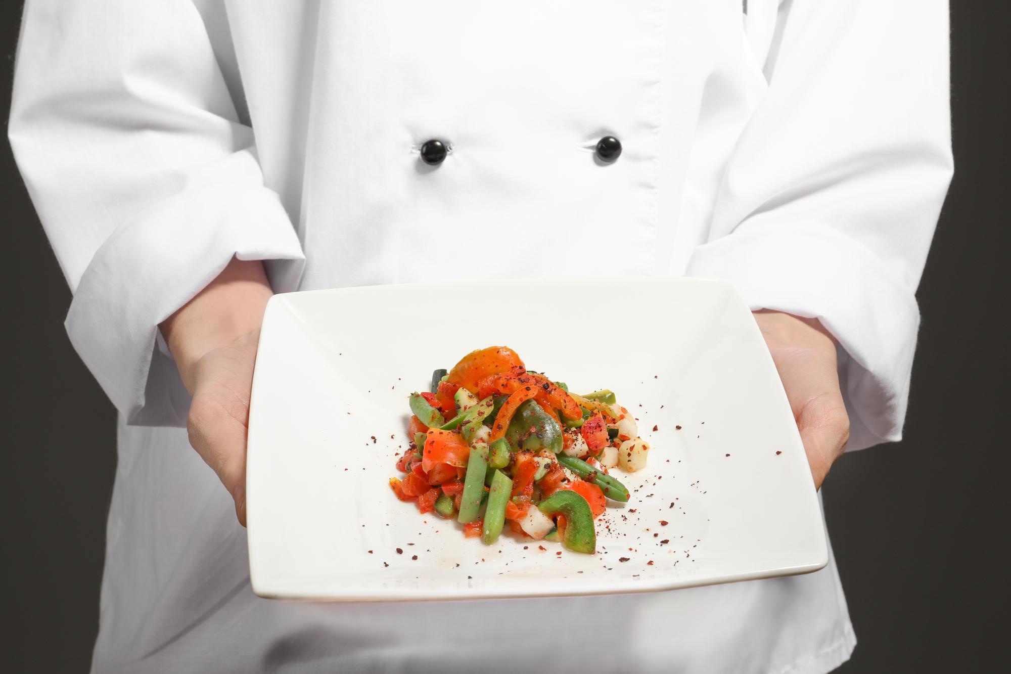 Chef che mostra un piatto in cucina domestica